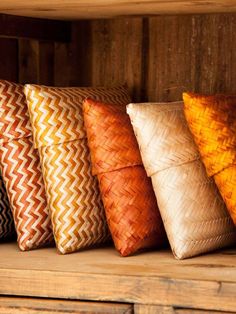 five decorative pillows lined up on a shelf