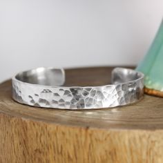 a silver bracelet sitting on top of a wooden table