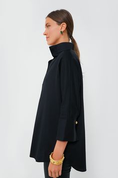 Crafted in a flattering silhouette from a crisp cotton poplin, the Black Willow Blouse is a must-have. Featuring a gold button front half-placket, stand collar, and high-low hem, this pullover pairs easily with everything from denim to leather all year long. Stand collar Three-quarter length sleeves Button cuffs Half-placket Gold buttons High-low hem Cotton poplin fabric Material: 97% Cotton, 3% Spandex Care: Machine wash cold, hang to dry Solid Color Stand Collar Tops For Work, Fall Workwear Top With Stand Collar, Fall Daywear Top With Stand Collar, Fall Stand Collar Top For Daywear, Solid Color Blouse With Stand Collar For Work, Elegant Long Sleeve Tunic With Buttons, Stand Collar Blouse With Button Closure For Work, Workwear Blouse With Button Cuffs And Stand Collar, Classic Stand Collar Blouse For Fall