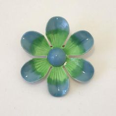 A 1960s mod enameled flower brooch. Fun and colorful, the brooch has blue and green flower petals radiating out from a Mediterranean blue center. Good vintage condition Measures 1.75”d Mid-century Blue Brooches For Gifts, Green Flower-shaped Brooch Pins, Green Flower Shaped Brooch Pins, Green Flower Brooch Pins, Mid-century Green Brooch As A Gift, Green Flower-shaped Enamel Brooch Pin, Green Flower Shaped Enamel Pin Brooch, Green Flower Enamel Pin Brooch, Vintage Green Flower Brooches