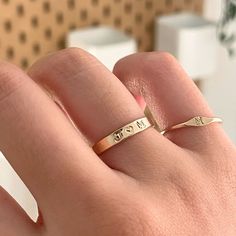 a woman's hand with a gold ring that says love on the middle finger