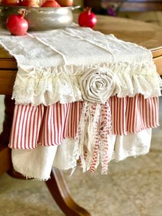 the table is covered with red and white ruffles, striped napkins, and apples