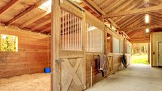 the inside of a horse barn with doors open