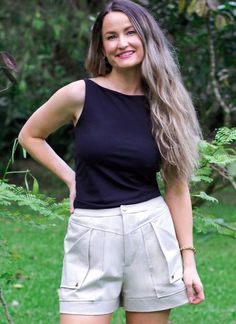 a woman standing in the grass with her hands on her hips