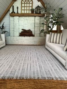 a living room with two couches and a rug on the floor in front of a fireplace