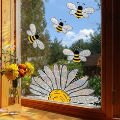 three bees are flying over a flower in front of a window