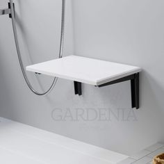 a white shelf sitting on the side of a wall next to a bathtub and shower head