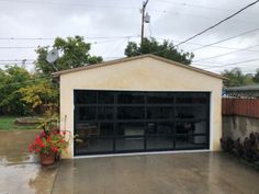 an image of a garage with flowers in the yard