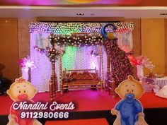 a stage set up for a baby shower with teddy bears on the floor and decorations