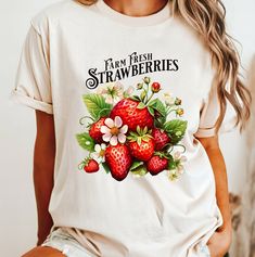 A charming print of vintage strawberries that adds a touch of retro flair to your everyday wardrobe. Perfect for lounging at home or pairing with jeans for a casual outing, this t-shirt promises both comfort and timeless style. Embrace the sweetness of yesteryears with our Strawberry Fields tee, your new favorite piece for relaxed elegance. This is an Ivory comfort color tshirt.  These Comfort Color Shirts are unisex sizing. For a relaxed look: order your normal size For an oversized look: size Cute Fruit Print T-shirt, Retro Spring Tops With Strawberry Print, Retro Spring Top With Strawberry Print, Cute Strawberry Print T-shirt For Spring, Trendy Fruit Design Tops For Spring, Retro Strawberry Print Summer Tops, White T-shirt With Strawberry Print For Spring, Retro Strawberry Print Tops For Summer, Vintage Summer Top With Fruit Print