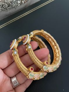 Classic & Elegant Pastel Meenakari Openable Bangle Pair in Antique Gold Finish studded with Kundan, Ruby stones & pearl piroyi. Pair this gorgeous Openable Bangles with any Traditional Indian Ethnic wear to get lot of compliments on your way. Available in size 2.4 & 2.6, great fit for bangle size 2.4-2.8 ✅Check other styles available in our store  https://www.etsy.com/shop/KKsCulture Send us an email if you need help!  SHIPPING & TURNAROUND  We follow item dispatch in 1-2 business days for most of our shipments. All pre orders will take approximately 3 weeks. We offer Free domestic delivery across US. Most deliveries are done in 2-5 business days via USPS. For any other query or assistance with shipping, please write to us.  ❤️ Whenever you buy something from a small business you are not o Ruby Bangles, Ruby Stone, Indian Ethnic Wear, Classic Elegant, Traditional Indian, Ethnic Wear, Gold Finish, 3 Weeks, Green And Gold