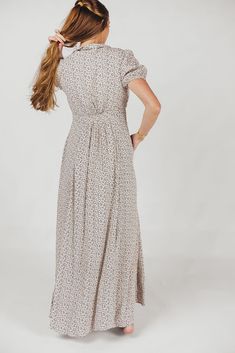 The Mariah Maxi Dress is a must-have for your cottagecore collection! This beautifully feminine dress features a collared V-neckline and a full front button placket; its dainty ditsy floral print is sweet and charming, perfect for dressing up for special occasions or wearing around the house. FIT: Runs a bit large on bust MATERIAL: Viscose. GARMENT DETAILS: Ditsy floral maxi dress with collared V-neckline, short sleeves with elasticized cuffs, and full front button placket. SIZE GUIDE: XS (0-2) / S (2-4) / M (6-8) / L (10-12) / XL (14-16) MODEL DETAILS: Mackenzie - Size S Heather - Size S Molly - Size XL Our Brunette Misses Model Our Blonde Misses Model Our Blonde Curve Model Bust 34" 34" 37" Waist 27.5" 27.5" 32" Hips 40.5" 37.5" 47" Height 5'7" 5'7" 5'7" Flowy Buttoned Dress For Garden Party, Spring Floral Print Dress With Collared Neckline, Spring Midi Dress With Notched Neckline In Feminine Style, Modest Ditsy Floral Print Dress For Daywear, Feminine Spring Midi Dress With Notched Neckline, Modest Ditsy Floral Dress For Daywear, Feminine Dresses With Buttons For Garden Party, Flowy Short Sleeve Maxi Dress With Buttons, Flowy Maxi Dress With Buttons And Short Sleeves