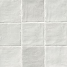 a white tiled wall with several squares in it