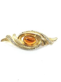 Exquisite CASTLECLIFF brooch all done on brilliant gold plated metal.  Huge oval openback topaz cabochon and open all around it.  Waves of brilliant textured gold and pave clear chatons , three waves to the right and three to the left.  Measuring 3 1/2" by 1 3/8".  BREATHTAKINGLY BEAUTIFUL! Luxury Art Nouveau Cabochon Brooch, Luxury Silver Cabochon Brooch, Luxury Yellow Gold Cabochon Brooch, Luxury Modernist Cabochon Jewelry, Luxury Oval Cabochon Brooch Jewelry, Luxury Oval Cabochon Brooch, Gold Texture, Brooch Pin, Brooches