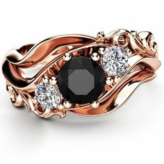 a black diamond ring with three diamonds on it's sides and the center stone surrounded by leaves