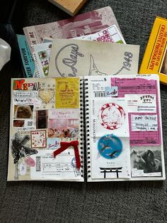 an open notebook covered in lots of different types of stickers and papers on the floor