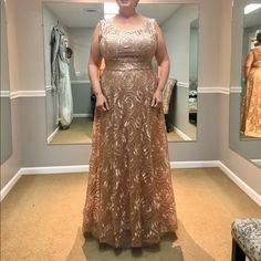 a woman standing in front of a mirror wearing a dress with gold sequins