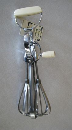 a kitchen utensil holder is attached to the wall by a metal handlebar