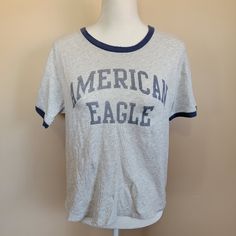 American Eagle Outfitters Short Sleeve T-Shirt Crop Size S Silver Casual T-shirt With Letter Print, Casual Silver T-shirt With Letter Print, Casual Silver Crew Neck Top, Silver Crew Neck T-shirt With Letter Print, Spring Silver Crew Neck Tops, Casual Silver Tops With Graphic Print, Casual Silver Top With Graphic Print, Casual Silver Tops For Spring, Silver Casual Short Sleeve T-shirt