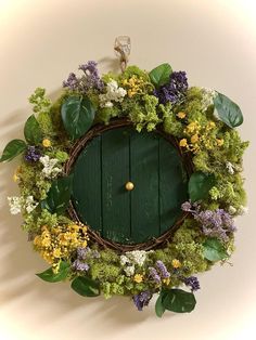 a green door surrounded by flowers and greenery