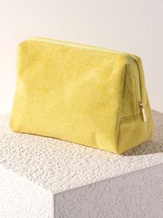 a yellow purse sitting on top of a white surface