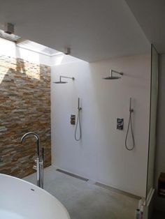 a large white bath tub sitting next to a walk in shower under a skylight