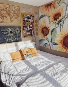 a bedroom with sunflowers painted on the wall and pictures hanging above the bed