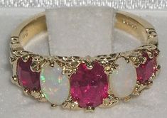 an opal and ruby ring set in yellow gold