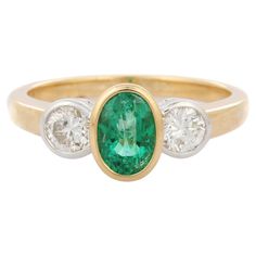 Emerald and diamond three stone ring in 18K Gold which perfectly goes with your personality and also helps you to improve your creativity. Designed with a oval cut emerald in center and diamonds on side that makes it a perfect fit to wear it on your wedding or style it with any of your basic outfit to give it a glam. PRODUCT DETAILS:- > Material - 18K Solid Yellow Gold > Gemstone - Emerald > Gemstone Weight - 0.88 ct > Gemstone pcs - 1 > Gemstone shape - Oval > Gemstone size - 7 x 5 mm > Diamond Latest Ring Designs, Engagement Story, Unique Wedding Jewelry, Diamond Three Stone Ring, Diamond Ring For Women, Deeper Meaning, Emerald Diamond Ring, Pink Sapphire Ring, Gold Gemstone Ring