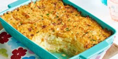 a casserole dish with cheese and parsley in it on a colorful tablecloth