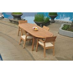 a wooden table and chairs next to a pool