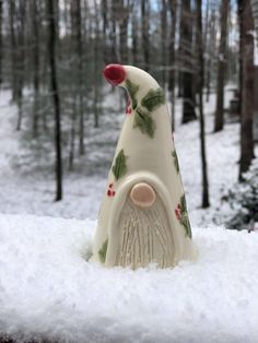 a ceramic gnome statue sitting in the snow