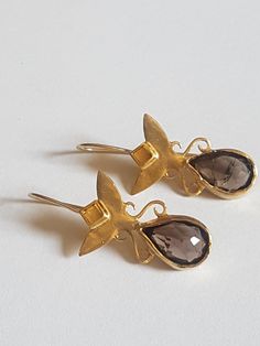 These Smokey quartz gemstone earrings were designed in a victorian, antique style for a royal, romantic look. The smokey earrings shine in a beautiful silky deep brown color. The earrings were carefully handmade and they are very dominant, royal and elegant. The brown and gold earrings are made in 14k gold plating, and can be also ordered in sterling silver. Convo me. They can be ordered with other stones as well (see last photo). Dimensions: The earrings total drop is 1.25 inches They are 1 inc Green Amethyst Earrings, Smoky Quartz Earrings, Gold Earrings Wedding, Gemstone Earrings Gold, Brown Gemstone, Earrings Teardrop, Earrings Gemstone, Earrings Antique, Green Earrings