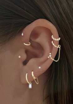 a woman's ear with three different types of piercings