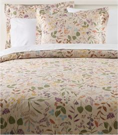 an image of a bed with floral comforter set on it's headboard