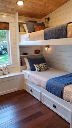 two bunk beds in a room with wooden floors and white walls, one is built into the wall