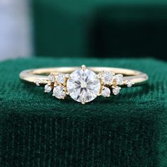 a diamond ring sitting on top of a green velvet cushion