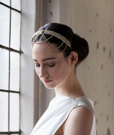 a woman in a white dress wearing a gold head piece