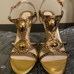 American Glamour Badgley Mischka Heels Leather With Gold Stone Embellishments. Color: Gold Never Used Heel 3.5” Offers Are Welcome Glamorous Gold Sandals For Cocktail, Glamorous Gold Sandals For Party Season, Elegant Gold Sandals For Holidays, Elegant Gold Sandals For Party Season, Elegant Gold Sandals For Party, Chic Embellished Gold Heels, Chic Gold Embellished Heels, Glamorous Gold Heels With Rhinestones, Gold High Heel Sandals For Holiday