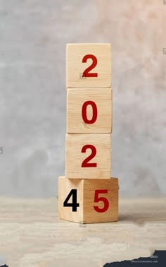 a wooden block with numbers on it sitting in front of a gray background that says 2012