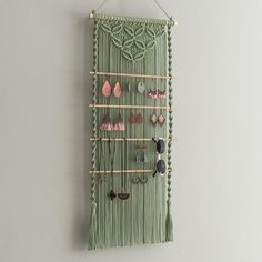 a green wall hanging with earrings on it