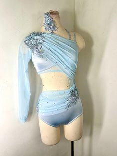 a female mannequin wearing a blue and white outfit with flowers on it's chest