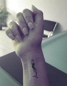 a woman's arm with a small tattoo on it