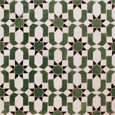 a green and white tiled wall with geometric designs