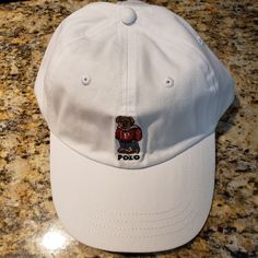 Polo Ralph Lauren Mens Limited Polo Varsity Bear Logo White Cap Hat Osfa $49 Nwt Brand New With Tags Never Worn Polo Ralph Lauren Mens Limited Polo Varsity Bear Logo White Cap Hat Limited Edition Polo Ralph Lauren "Polo Bear" Collection Size - Adjustable Cloth Strap With "Polo" Metal Clasp - One-Size Fits All - Osfa Color - White Beautifully Embroidered "Varsity Polo Bear" Logo On Front Of Cap "Polo Ralph Lauren" Embroidered On Back In Navy Blue 100% Cotton Cotton Sweatband Msrp - $49.50 From Sm Casual White Dad Hat With Flat Bill, White Sporty Dad Hat With Flat Bill, White Adjustable Dad Hat, Classic White Dad Hat, White Flat Bill Dad Hat For Outdoor, Everyday White Six-panel Baseball Cap, Classic White Hat For Outdoor, White Cotton Baseball Cap Flat Bill, White Curved Brim Dad Hat For Outdoor