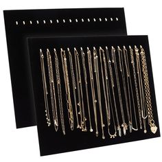 two black velvet jewelry displays with gold chains and pendants on each one side,