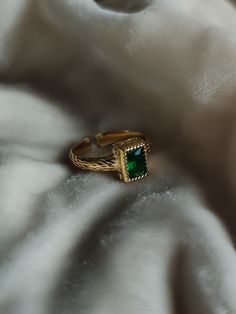 Beautiful gold ring with a bezel set emerald green stone. The band features a textured finish for a unique antique feel. Band is pvd gold coated stainless steel that is waterproof and won't tarnish. Features an open back, so there is some room for adjusting the band by a few mm.  Inner diameter of ring is 18 mm. Height of stone approx. 7 mm. Dark Academia Rings, Ring Stack Gold, Thick Gold Band, Antique Emerald Ring, Emerald Stone Rings, Beautiful Gold Rings, Gold Emerald Ring, Royal Rings, Emerald Green Stone