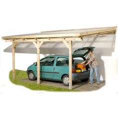 a man standing next to a blue car under a wooden structure