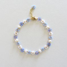 Blue flower bracelet with pearls Daisy flower bracelet for women  Freshwater pearl bracelet Gold Filled Jewelry Dainty Handmade Bracelet 24k gold plated brass chain and clasp. To determine your exact wrist/ankle size, get a tape measure! The bracelet is made of light blue and white Czech beads size 10/0 (about 2mm diameter), freshwater pearls measuring about 4mm and a 24k gold plated clasp and extension chain. Cute and delicate daisy bracelet with pearls will add a light touch to your casual and holiday outfits! Lobster clasp and extender for length adjustment and easy removal. Cheap Light Blue Beaded Bracelets, Handmade Delicate Blue Bracelets, Adjustable Flower-shaped Pearl Jewelry, Dainty Flower-shaped Jewelry With Pearl Chain, Gold Pearl Flower Bracelets, Dainty Flower Shaped Pearl Charm Jewelry, Bracelet Pearl Ideas, Pearl Beads Bracelet, Rice Pearl Jewelry