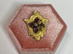 Gorgeous antique circa 1890s Victorian era 14k yellow gold brooch! This stunning brooch is Etruscan Revival and Ornate, that is accented with four genuine amethyst gemstones that are marquise cut and have a combined weight 0.8 ctw, with a single seed pearls in the center with two draped leafs to one side. A collectible piece of fine Victorian era jewelry, featuring Februarys Birthstone!  ERA - Circa 1890s - Victorian  METAL / MATERIAL - 14k yellow gold, 4 genuine amethyst ( estimated 0.8 ctw) ,1 seed pearl  MARKINGS / HISTORY - There are no markings but the metal has been professionally tested  CONDITION - Good antique condition. Yellow gold metal has been polished & cleaned. Age appropriate patina & wear remains. Gemstones are free of chips or scratches, and seed pearl is intact. Amazing Traditional Yellow Gold Brooches For Formal Occasions, Traditional Yellow Gold Formal Brooches, Traditional Yellow Gold Collectible Brooch, Vintage Yellow Gold Baroque Brooch, Ornate Gold Brooch With Rose Cut Diamonds, Ornate Gold Brooches With Rose Cut Diamonds, Traditional Yellow Gold Pendant Brooches, Antique Yellow Gold Hallmarked Brooches, Antique Hallmarked Yellow Gold Brooch